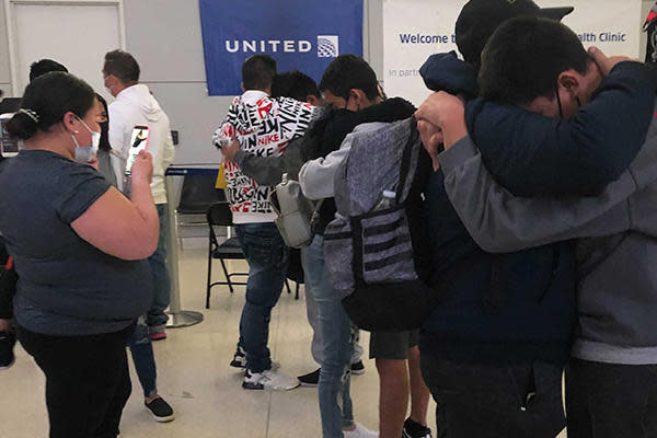 In the background, Elmer hugs his sister as his mother records in Newark Liberty International Airport on Sunday, May 2, 2021. / Credit: CBS News