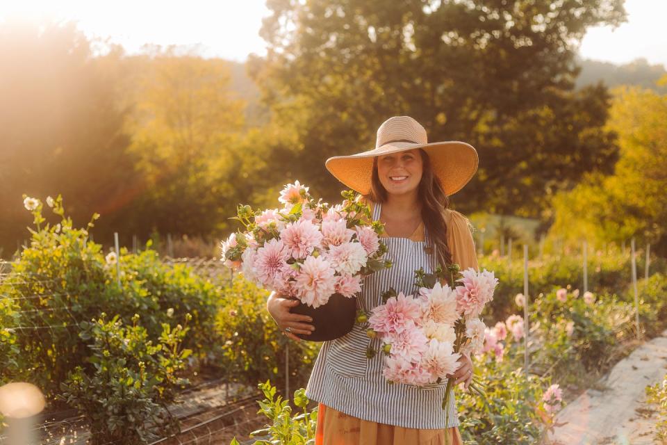 niki irving holding bouquets of dahlias at her asheville, north carolina farm