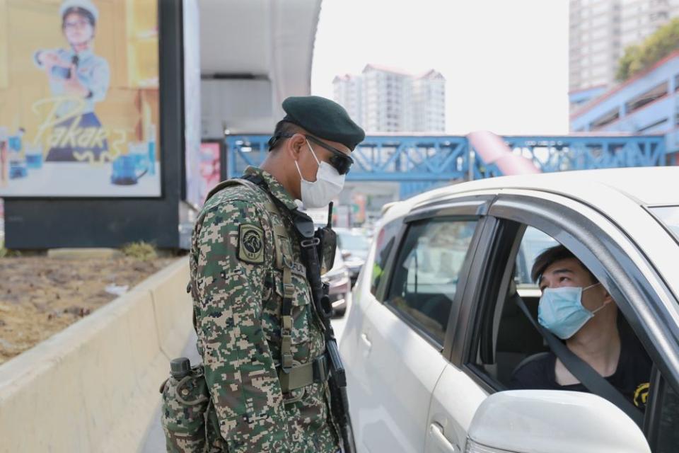 An Armed Forces personnel conducts checks on a vehicle during a roadblock in Petaling Jaya April 1, 2020. — Picture by Ahmad Zamzahuri