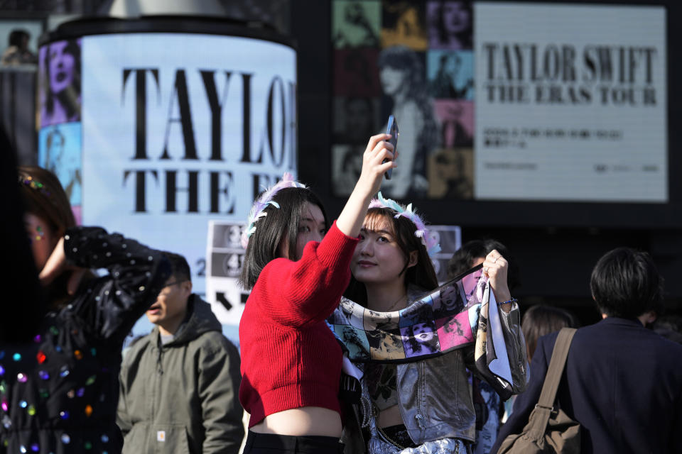 Women pose for a selfie before Taylor Swift's concert at Tokyo Dome in Tokyo, Saturday, Feb. 10, 2024. (AP Photo/Hiro Komae)