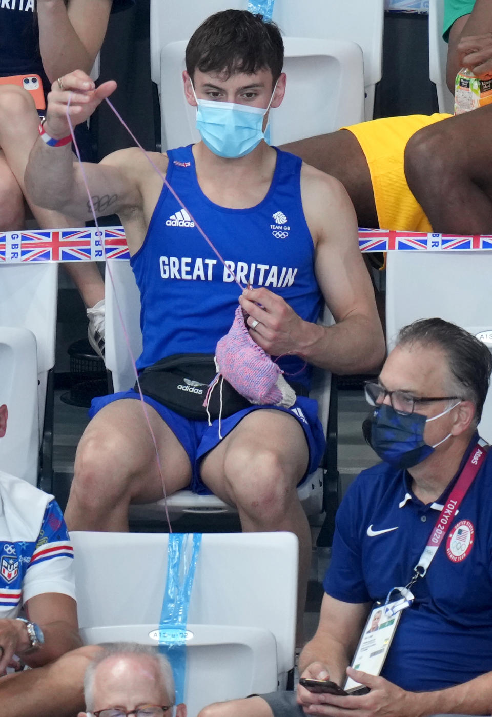 Tom Daley knits in the stands. (Joe Giddens / PA Images / Getty Images)