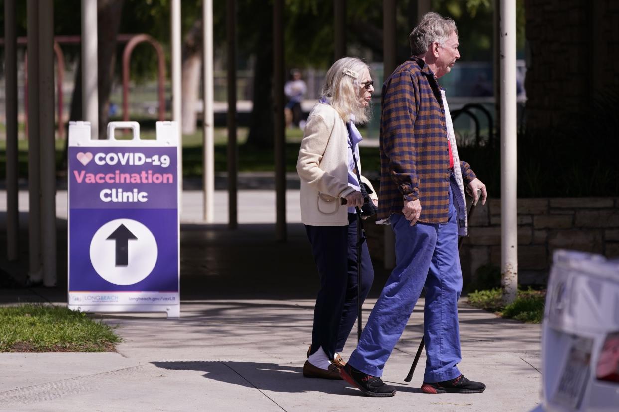 People leave a testing and vaccination clinic for COVID-19 Wednesday, March 30, 2022, in Long Beach, Calif. 