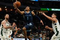 Memphis Grizzlies' Kennedy Chandler shoots between Milwaukee Bucks' Grayson Allen snd Sandro Mamukelashvili during the second half of an NBA preseason basketball game Saturday, Oct. 1, 2022, in Milwaukee. (AP Photo/Morry Gash)