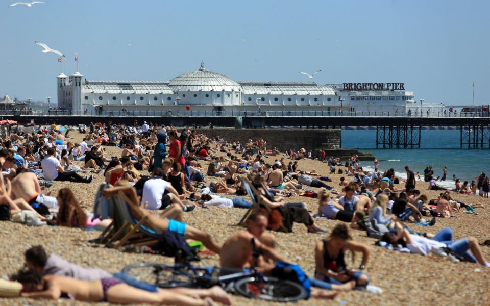 People enjoy the warm weather on the beach in Brighton, East Sussex -  Gareth Fuller/Getty Images