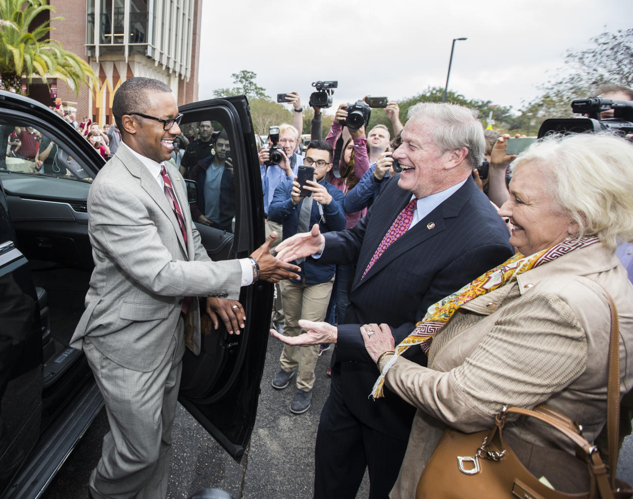 Willie Taggart (L) is greeted by Florida State University president John Thrasher and his wife, Jean, as he arrives to be introduced as the school’s new football head coach. (AP Photo/Mark Wallheiser)