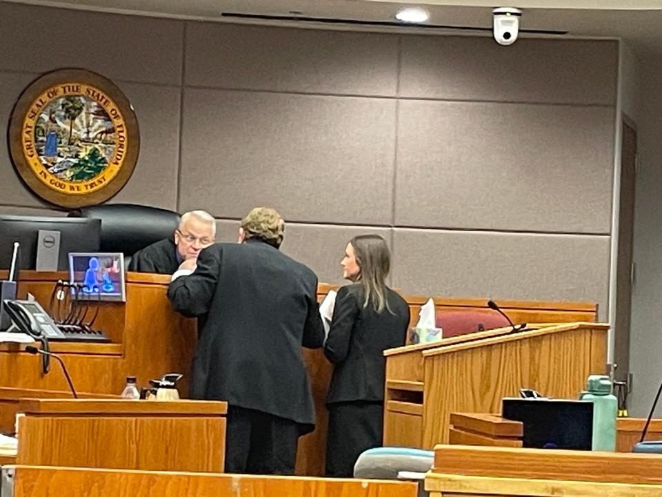 Lawyers Jack Maro and Elizabeth White talk with Circuit Judge Peter Brigham at Kevin William Ernest's trial.