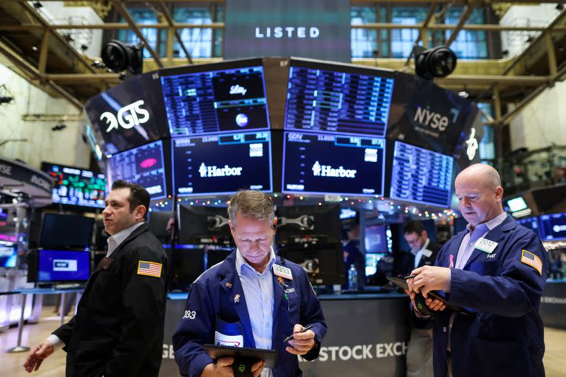 FILE PHOTO: Traders work on the trading floor at the New York Stock Exchange (NYSE) in New York City