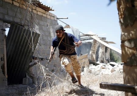 A fighter of Libyan forces allied with the U.N.-backed government runs for cover during a battle with Islamic State fighters in Sirte, Libya, July 31, 2016. REUTERS/Goran Tomasevic/File Photo