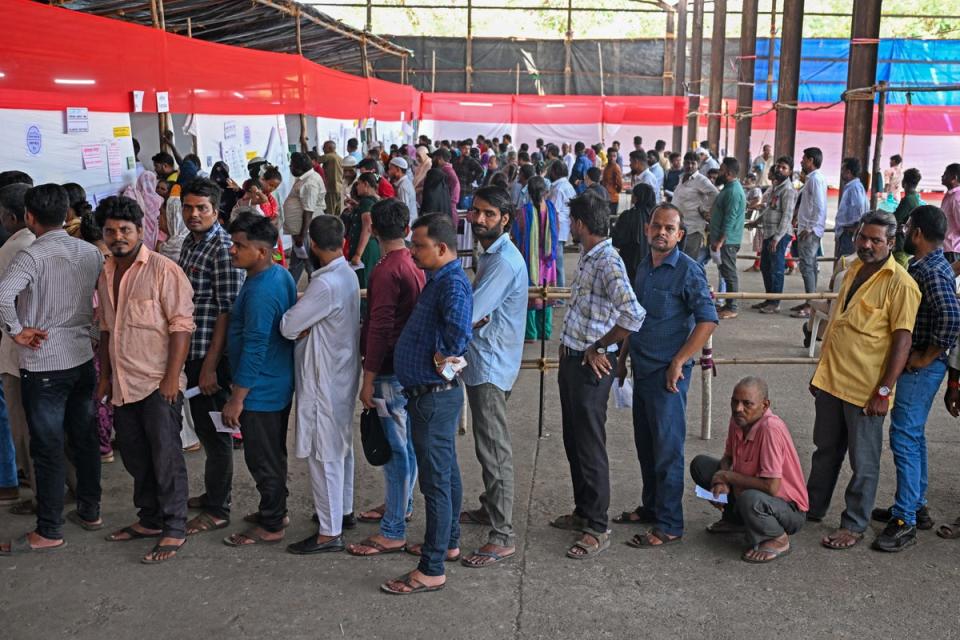 People queue up to cast their votes at a polling station in Mumbai (Getty)