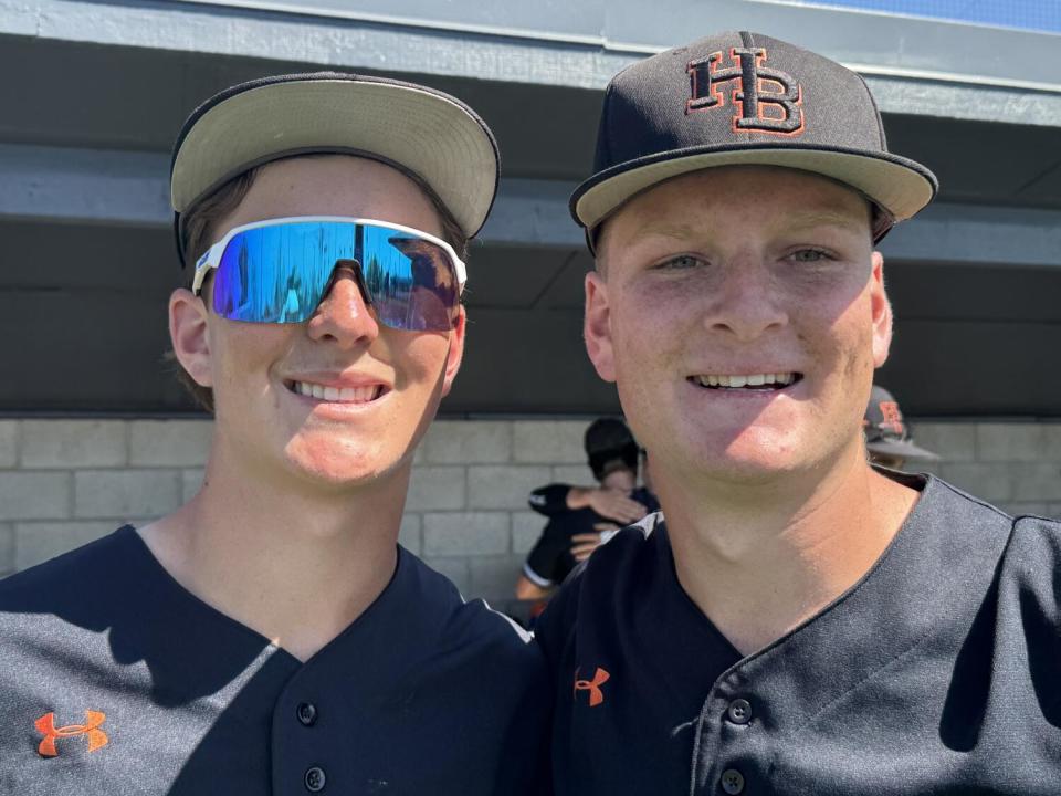 Brothers Jared and Trent Grindlinger smile in their baseball uniforms.