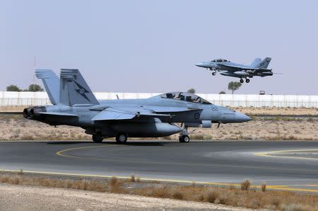 A Royal Australian Air Force (RAAF) F/A-18F Super Hornet takes off as another taxis along the runway as they start their first combat mission over Iraq in this picture released by the Australian Defence Force October 6, 2014. REUTERS/Australian Defence Force/Handout