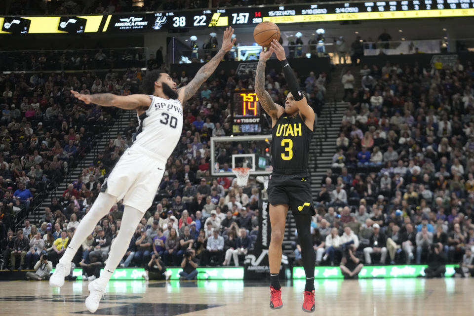 Utah Jazz guard Keyonte George (3) shoots as San Antonio Spurs forward Julian Champagnie (30) defends during the first half of an NBA basketball game Wednesday, March 27, 2024, in Salt Lake City. (AP Photo/Rick Bowmer)