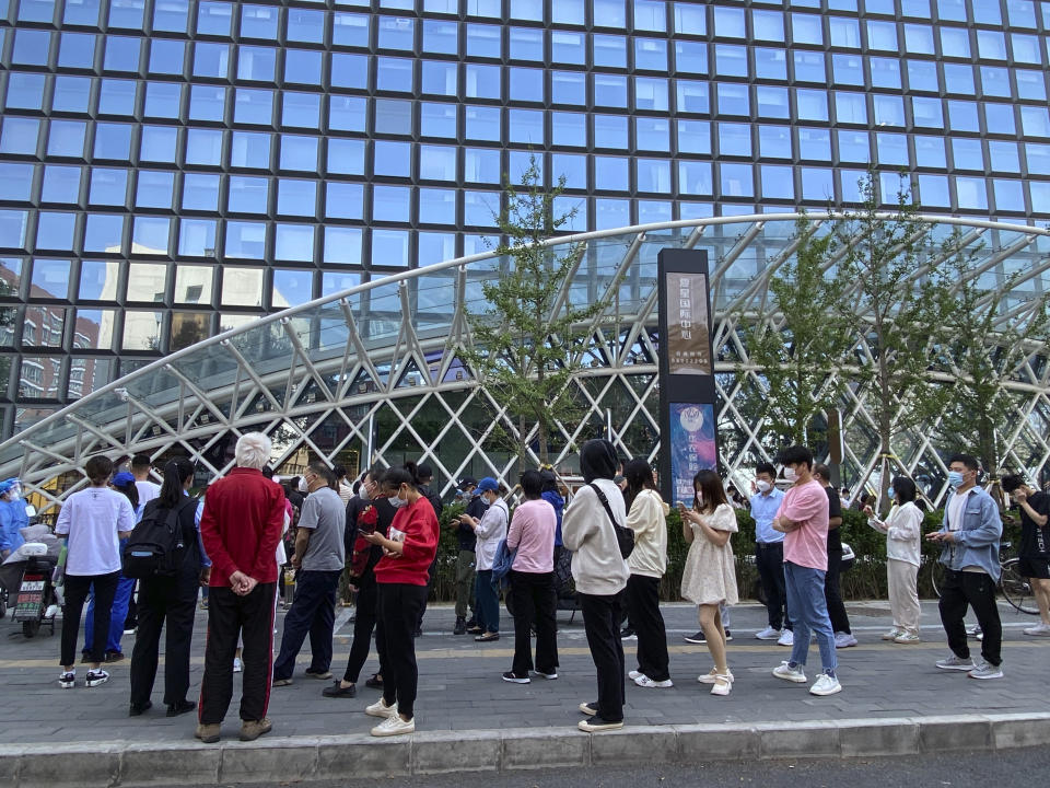 People wearing face masks stand in line for COVID-19 tests at a testing site during the second consecutive day of mass testing in Beijing, Wednesday, May 4, 2022. Beijing on Wednesday closed around 10% of the stations in its vast subway system as an additional measure against the spread of coronavirus. (AP Photo/Mark Schiefelbein)