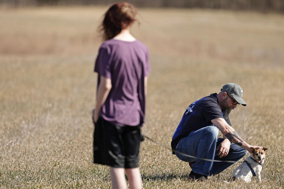 Dusty Farr pets their dog Allie while at a park with his transgender daughter near Smithville, Mo., Sunday, Feb. 25, 2024. Farr is suing the Platt County School District after his daughter was suspended for using the girl's bathroom at the Missouri high school she attended. (AP Photo/Charlie Riedel)