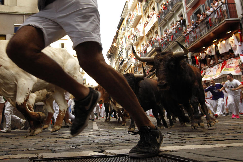 Revellers run next to fighting bulls from Cebada Gago ranch, during the running of the bulls at the San Fermin on July 8, 2019.  (Photo: Alvaro Barrientos/AP)