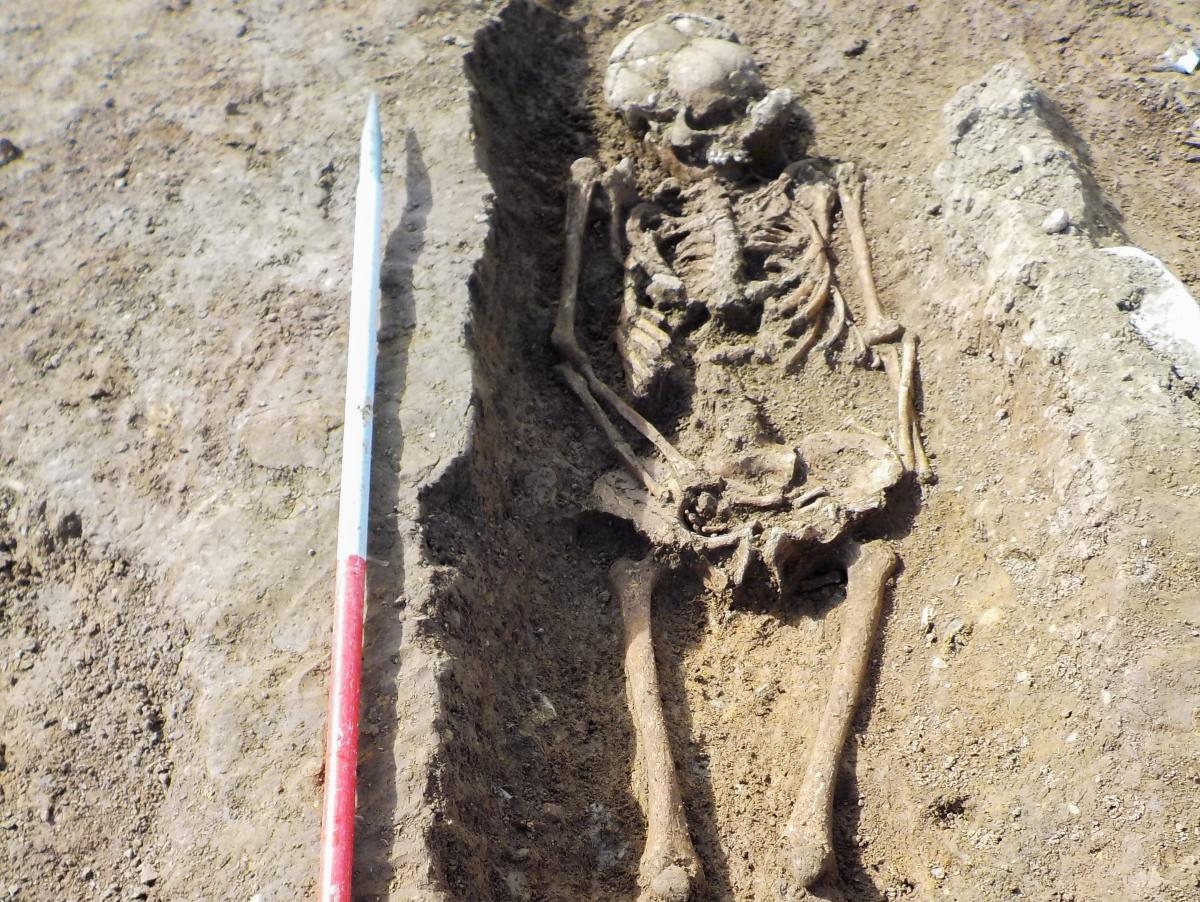 A decapitated skeleton with its skull mysteriously placed at his feet and a  'mercenary' buried with his sword have been discovered in Roman-era graves