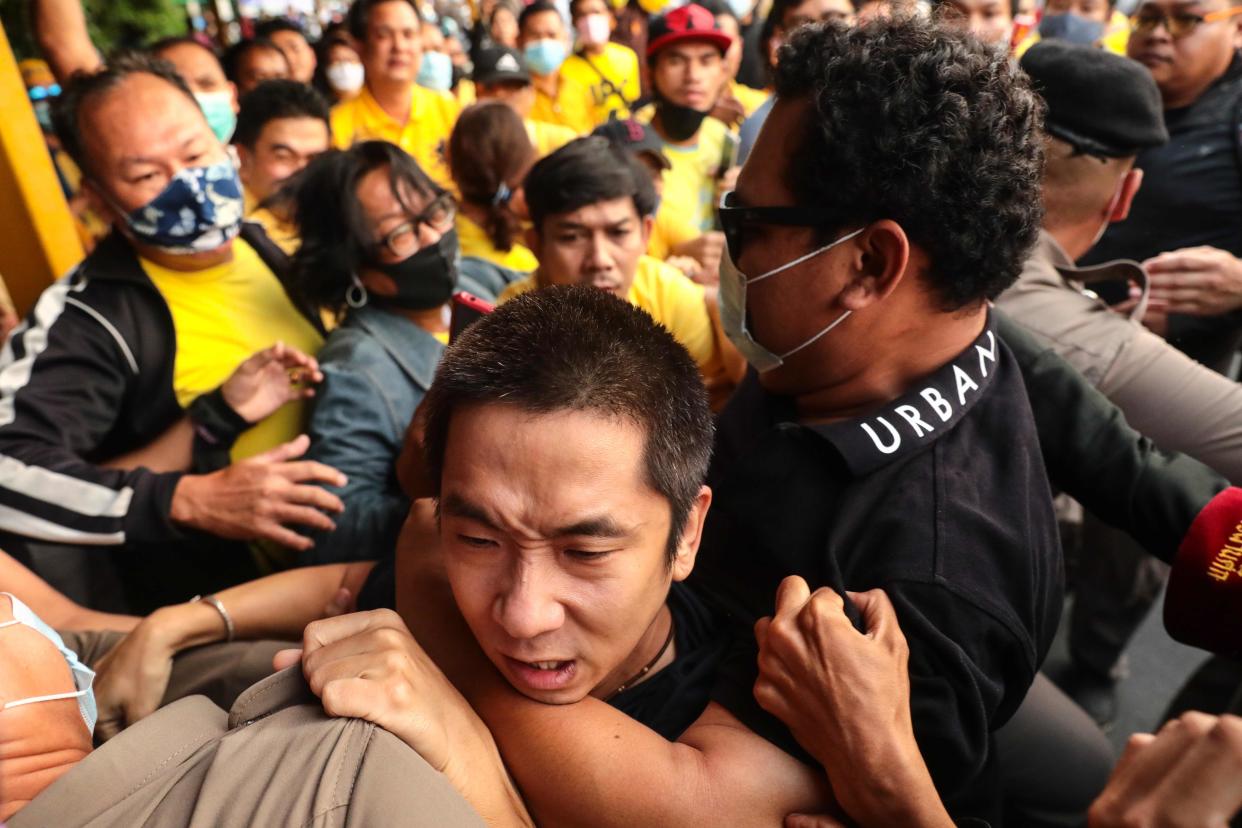 A man is held back during scuffles between royalist supporters and pro-democracy protesters at Ramkhamhaeng University in Bangkok on Wednesday (AFP via Getty Images)