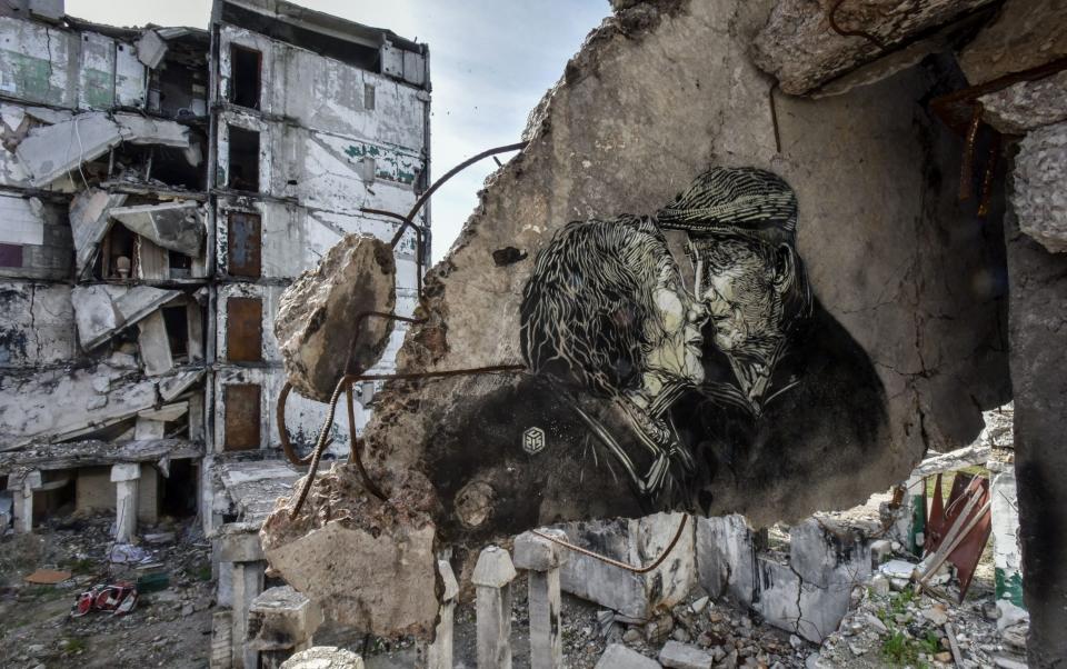 A portrait of an elderly couple, made by street artist Christian Guemy, known as C215, on the wall of a house destroyed by Russian shelling in 2022, in Borodyanka, Kyiv region - OLEG PETRASYUK/EPA-EFE/Shutterstock/Shutterstock