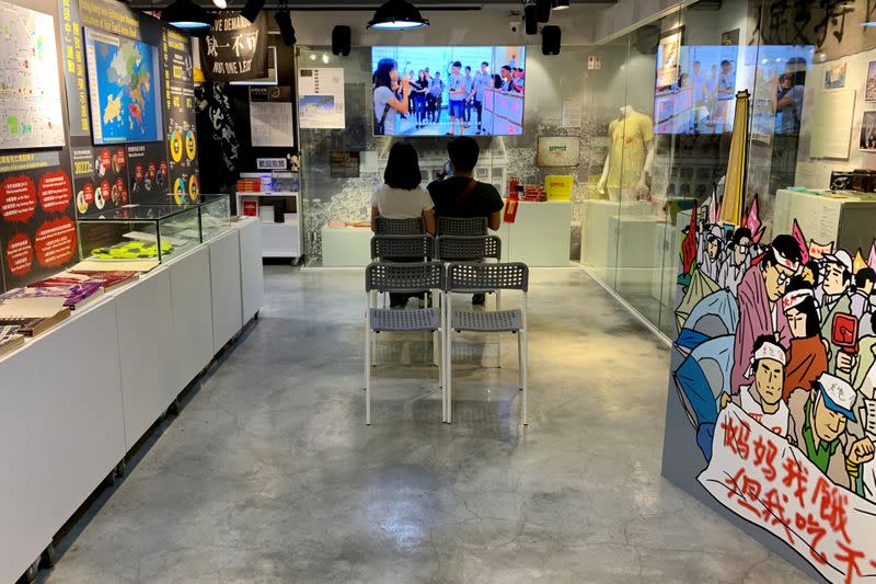 Couple watches a documentary about the Tiananmen Square crackdown at the June 4th museum in Hong Kong