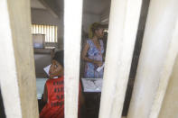 A woman waits to cast her vote in the presidential election in Lome, Togo, Saturday, Feb. 22, 2020. The West African nation of Togo is voting Saturday in a presidential election that is likely to see the incumbent re-elected for a fourth term despite years of calls by the opposition for new leadership. (AP Photo/Sunday Alamba)