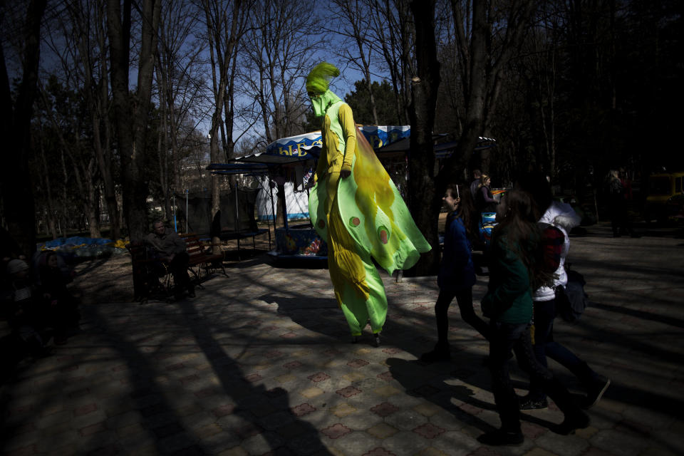 A Ukrainian man on stilts walks in a park in Simferopol, Ukraine, Friday, March 15, 2014. Tensions are high in the Black Sea peninsula of Crimea, where a referendum is to be held Sunday on whether to split off from Ukraine and seek annexation by Russia. (AP Photo/Manu Brabo)