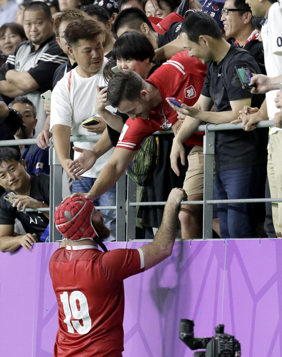 Canada's Mike Sheppard talks with a friend in the crowd following their Rugby World Cup Pool B game at Oita Stadium in Oita, Japan, Wednesday, Oct. 2, 2019. The All Blacks defeated Canada 63-0. (AP Photo/Aaron Favila)