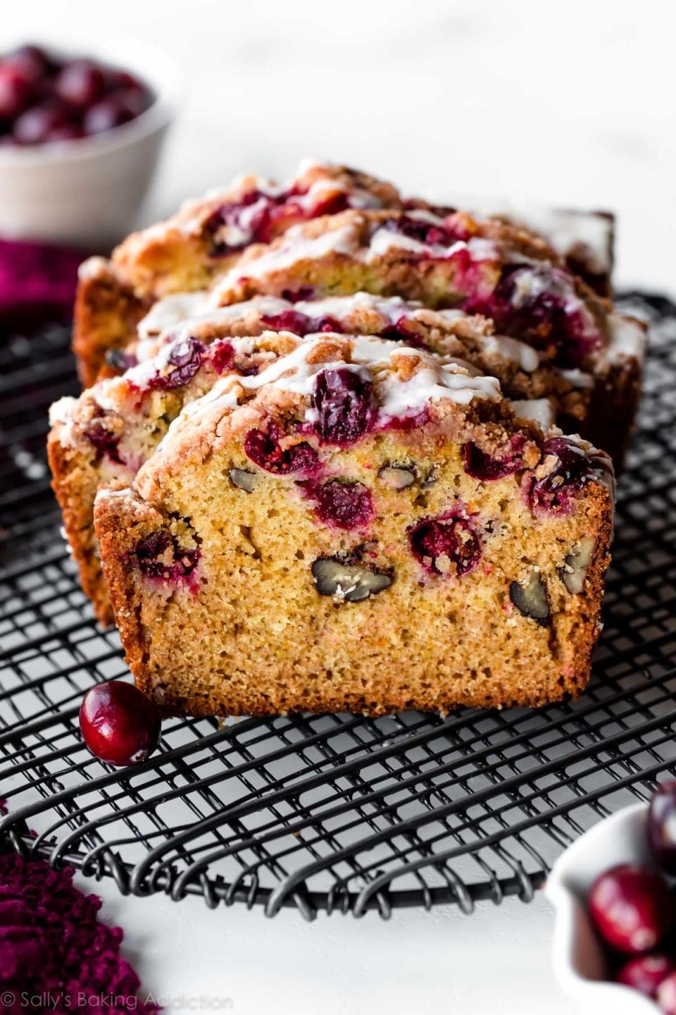 a sliced orange cranberry bread on a cooling rack