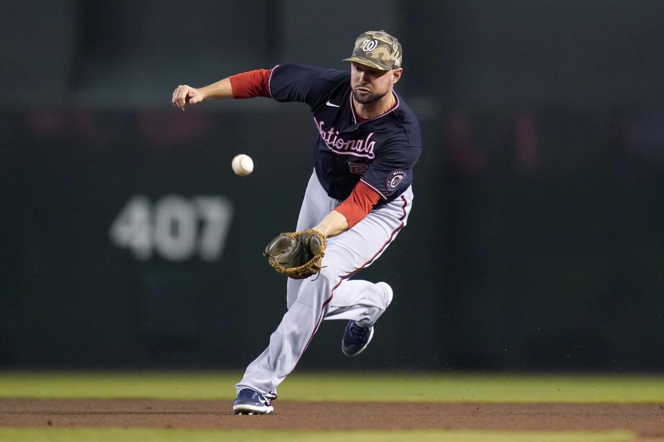 Washington Nationals second baseman Jordy Mercer reaches out to field a grounder hit by Arizona Diamondbacks' David Peralta before throwing to first base for an out during the first inning of a baseball game Sunday, May 16, 2021, in Phoenix. (AP Photo/Ross D. Franklin)