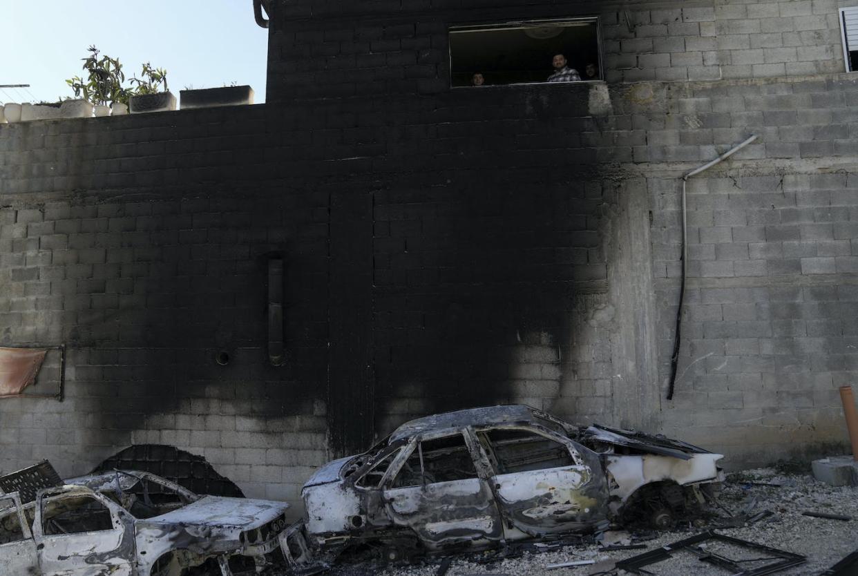 Palestinians look out from a damaged building next to scorched cars in the town of Hawara, near the West Bank city of Nablus, on Feb. 27, 2023. <a href="https://newsroom.ap.org/detail/IsraelPalestinians/b86627dc8b494251a271b1aa0a4f4ec6/photo?Query=west%20bank&mediaType=photo&sortBy=&dateRange=Anytime&totalCount=25904&currentItemNo=42" rel="nofollow noopener" target="_blank" data-ylk="slk:AP Photo/Nasser Nasser;elm:context_link;itc:0;sec:content-canvas" class="link ">AP Photo/Nasser Nasser</a>