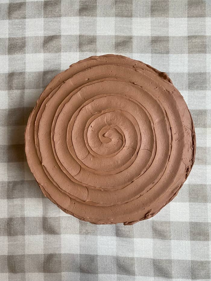 a top shot of a chocolate cake frosted in a swirl pattern