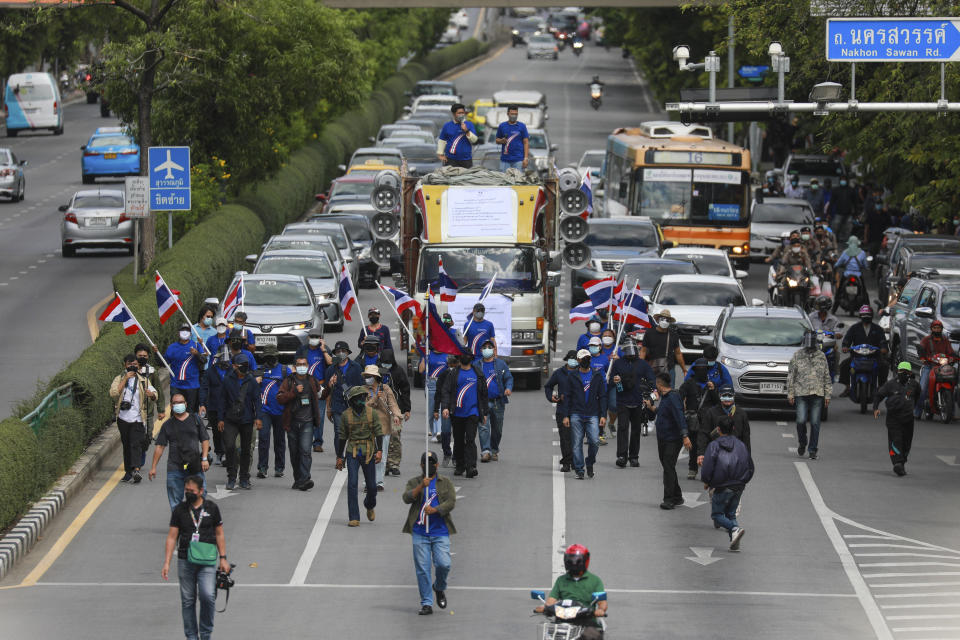 Pro-democracy supporters march along a road during a demonstration in Bangkok, Thailand, Thursday, June 24, 2021. Pro-democracy demonstrators have taken to the streets of Thailand's capital again, marking the 89th anniversary of the overthrow of the country's absolute monarchy by renewing their demands that the government step down, the constitution be amended and the monarchy become more accountable. (AP Photo/Wason Wanichakorn)