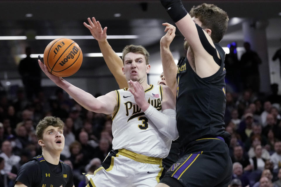 Purdue guard Braden Smith (3) passes the ball against Northwestern center Matthew Nicholson, right, during the first half of an NCAA college basketball game in Evanston, Ill., Sunday, Feb. 12, 2023. (AP Photo/Nam Y. Huh)