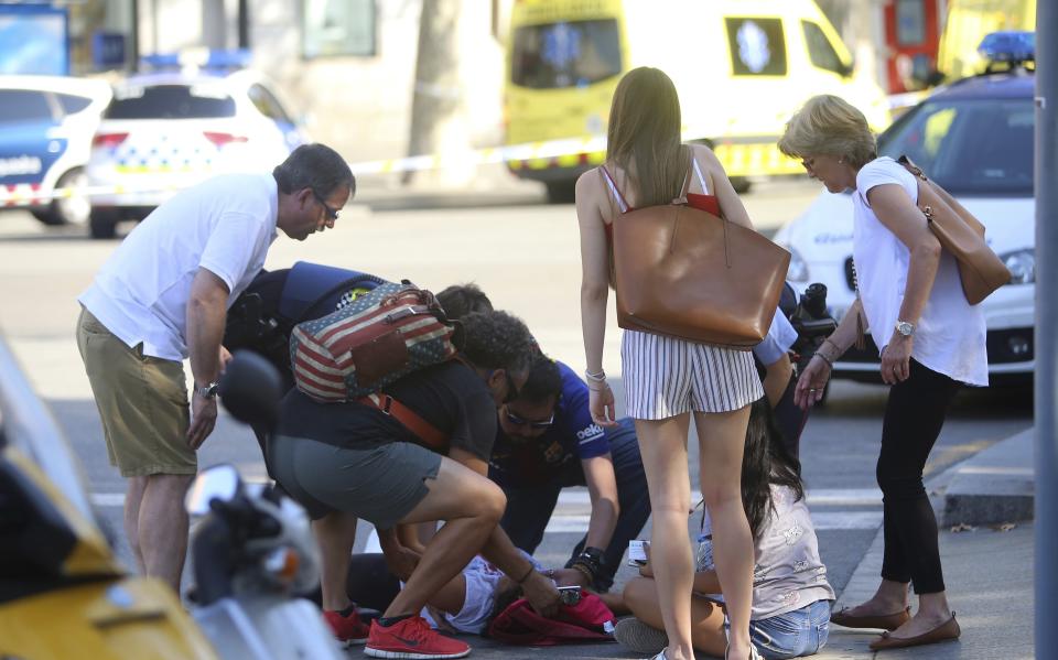 Passers-by rush to help someone injured in Las Ramblas (Rex)