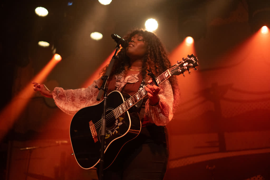 Black country artists that are up-and-coming and making history. Pictured: Brittney Spencer playing guitar and singing. | BIRMINGHAM, ALABAMA - FEBRUARY 10: Brittney Spencer performs at Iron City on February 10, 2024 in Birmingham, Alabama. (Photo by David A. Smith/Getty Images)