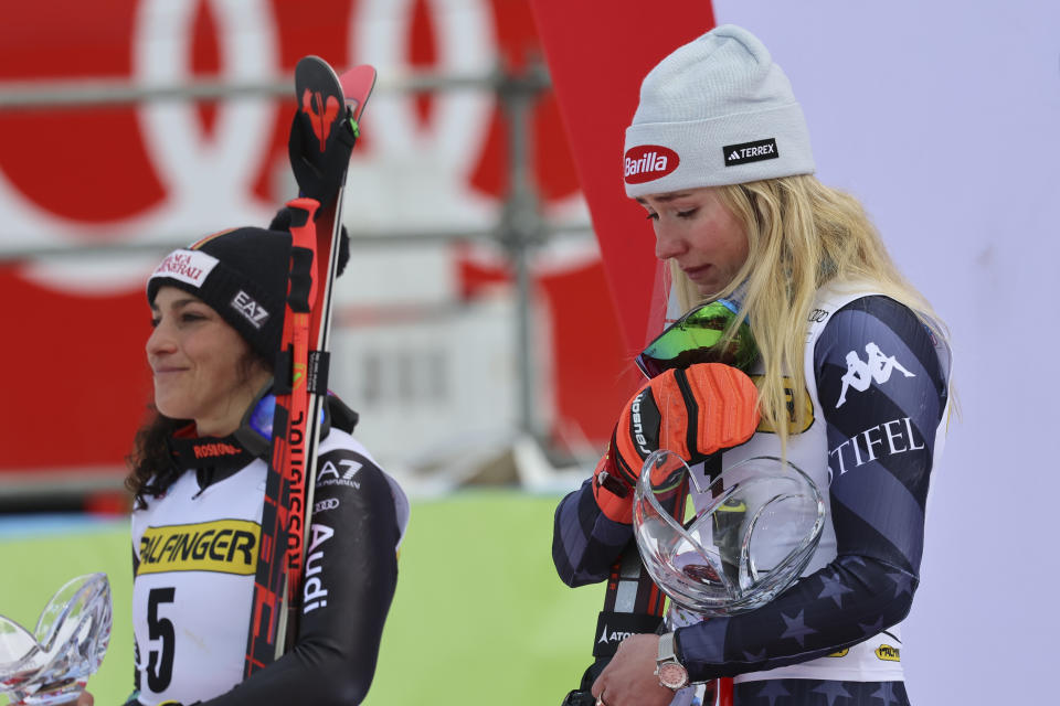 United States' Mikaela Shiffrin, right, winner of an alpine ski, women's World Cup giant slalom race, is overcome by emotion as she listens to the national anthem on the podium with second-placed Italy's Federica Brignone, left, in Kranjska Gora, Slovenia, Sunday, Jan. 8, 2023. Shiffrin matched Lindsey Vonn's women's World Cup skiing record with her 82nd win Sunday. (AP Photo/Marco Trovati)