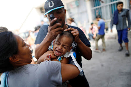 A boy, a member of a migrants caravan from Central America, gets his hair cut at the end of the caravan journey through Mexico, prior to preparations for an asylum request in the U.S., in Tijuana, Baja California state, Mexico April 26, 2018. REUTERS/Edgard Garrido