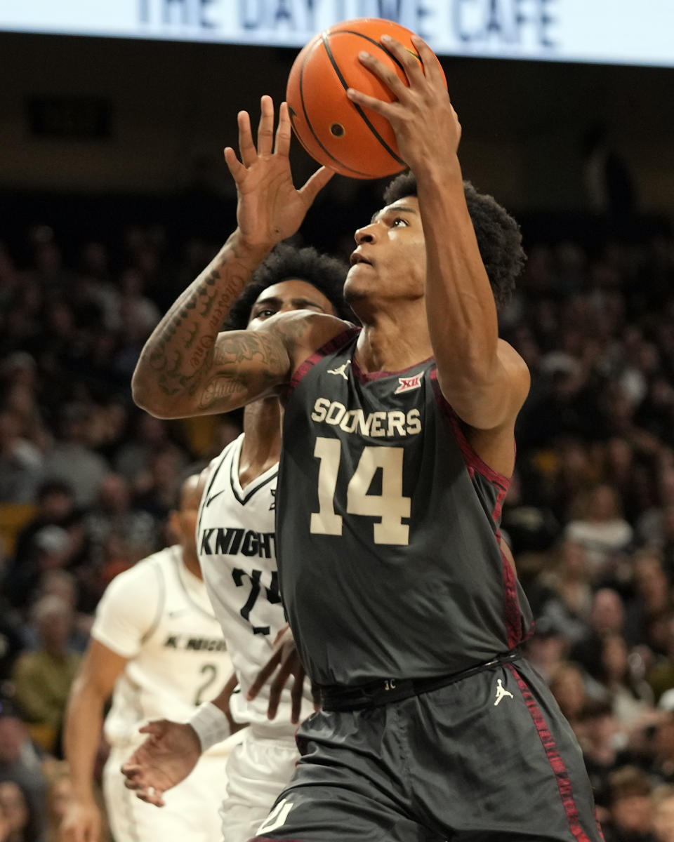 Oklahoma forward Jalon Moore (14) goes past Central Florida guard Jaylin Sellers, left, for a shot during the first half of an NCAA college basketball game, Saturday, Feb. 3, 2024, in Orlando, Fla. (AP Photo/John Raoux)