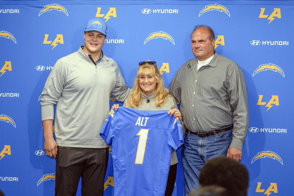 Los Angeles Chargers draft Joe Alt, left poses with his parents, Carolyn, center, and John Alt, right, as he is introduced at an NFL football news conference Friday, April 26, 2024, in Costa Mesa, Calif. John is a former NFL player who was a first-round pick for the Kansas City Chiefs in the 1984 draft. (AP Photo/Damian Dovarganes)