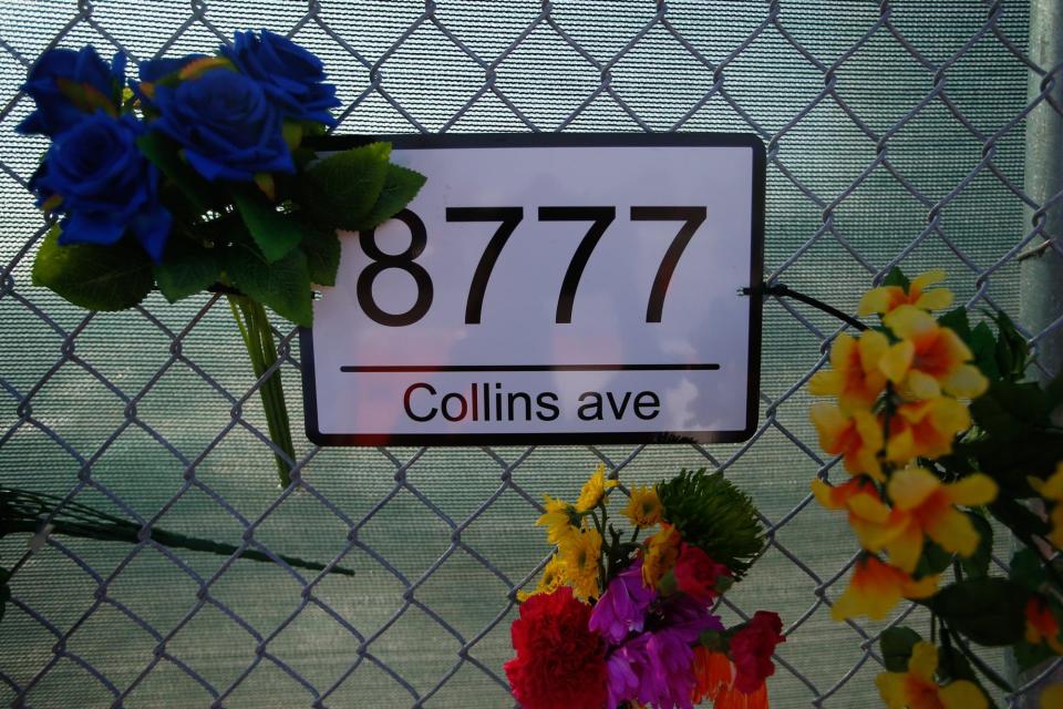 Flowers are seen on a chain-link fence marking the address of the former location of Champlain Towers South condo in Surfside, FL., on Friday, June 24, 2022.