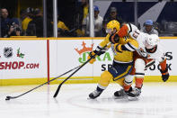 Nashville Predators left wing Cole Smith (36) moves the puck in front of Anaheim Ducks defenseman Simon Benoit (13) during the second period of an NHL hockey game Tuesday, Nov. 29, 2022, in Nashville, Tenn. (AP Photo/Mark Zaleski)