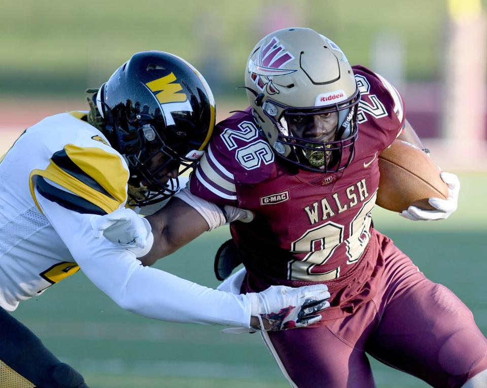 Walsh running back Cam Macon (26) gains yardage during the first quarter of Thursday's season opener against West Liberty.