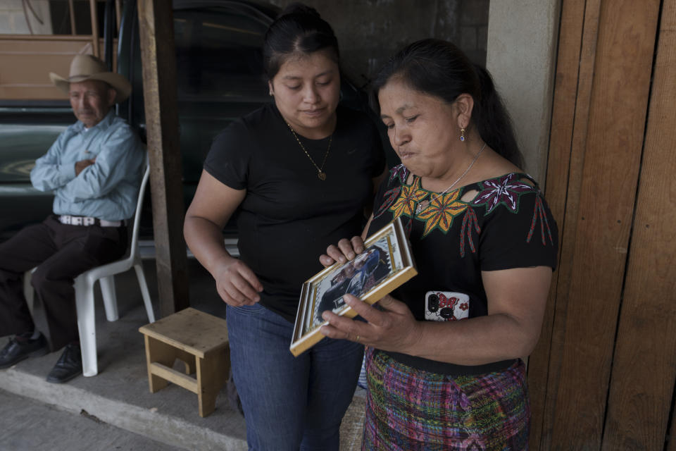 Ana Marina Lopez, wife of Guatemalan migrant Bacilio Sutuj Saravia who died in a fire at a Mexican migrant detention center, holds a photo of her late husband, accompanied by her daughter Silvia, during an interview in San Martin Jilotepeque, Guatemala, Wednesday, March 29, 2023. According to Mexican President Andres Manuel Lopez Obrador, migrants fearing deportation set mattresses ablaze late Monday at the center, starting a fire that left more than three dozen dead. (AP Photo/Moises Castillo)