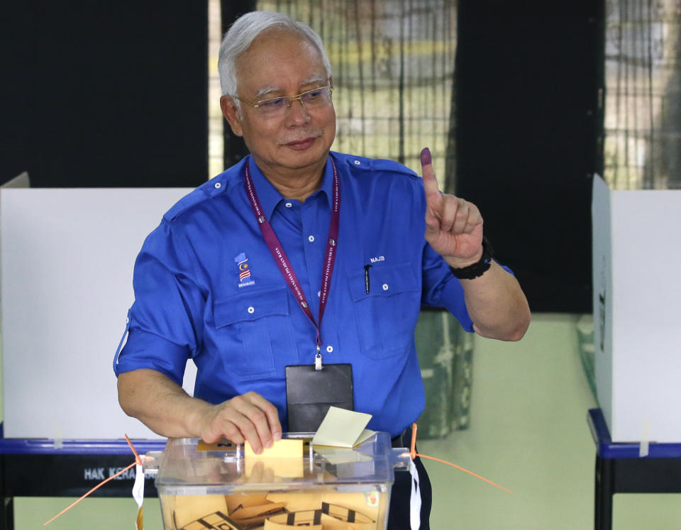 FILE - Malaysian Prime Minister Najib Razak looks at his finger marked with ink as he votes for the general election, at his hometown in Pekan, Pahang state, Malaysia on Wednesday, May 9, 2018. Najib Razak on Tuesday, Aug. 23, 2022 was Malaysia’s first former prime minister to go to prison -- a mighty fall for a veteran British-educated politician whose father and uncle were the country’s second and third prime ministers, respectively. The 1MDB financial scandal that brought him down was not just a personal blow but shook the stranglehold his United Malays National Organization party had over Malaysian politics. (AP Photo/Aaron Favila, file)