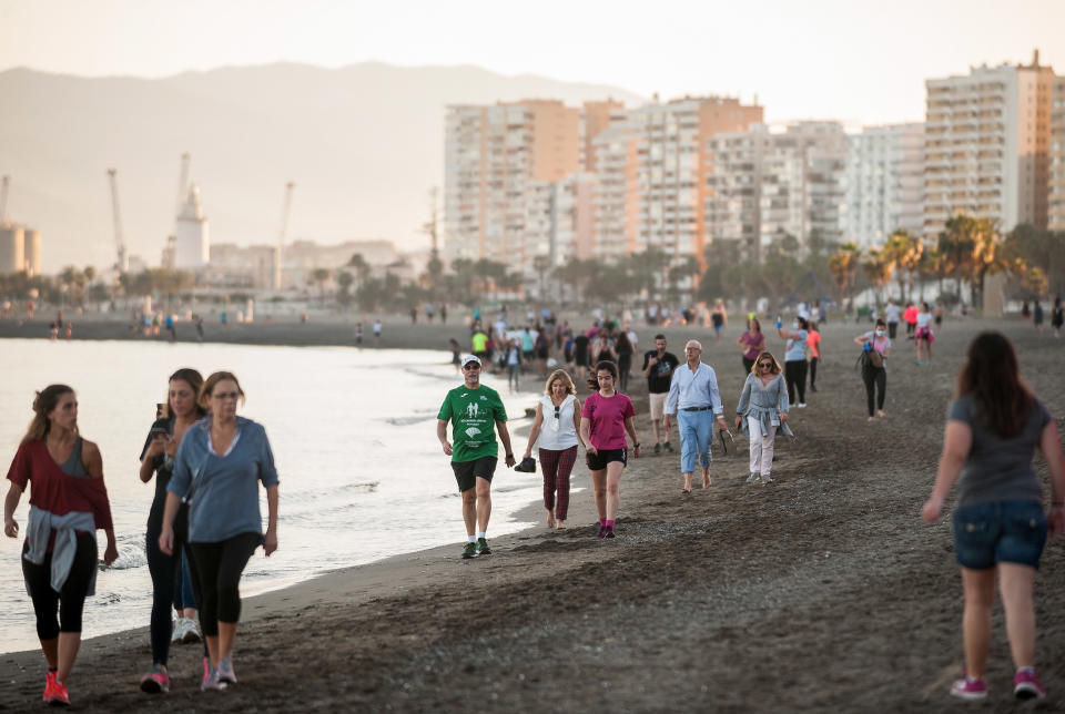 People take a walk on a Spanish beach at sunset amid the coronavirus crisis. Source: AAP