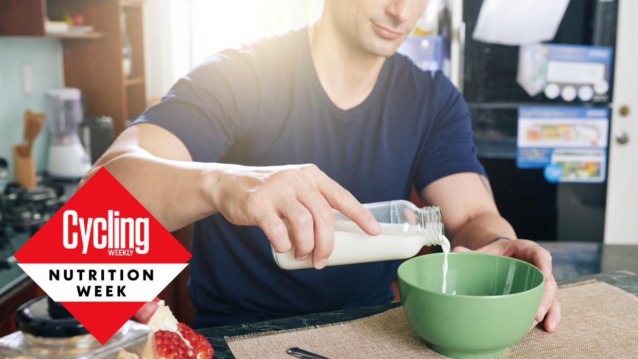   Male cyclist pouring milk into his cereal bowl for breakfast 