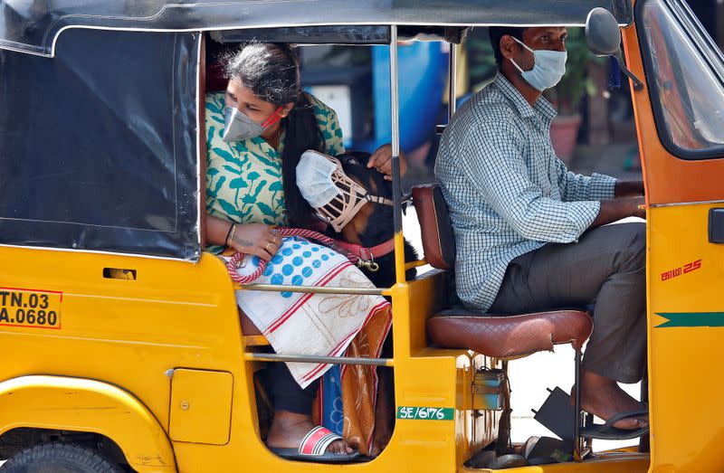 A dog wearing a protective mask is seen with its owner inside an autorickshaw during a 21-day nationwide lockdown to limit the spreading of coronavirus disease (COVID-19) in Chennai