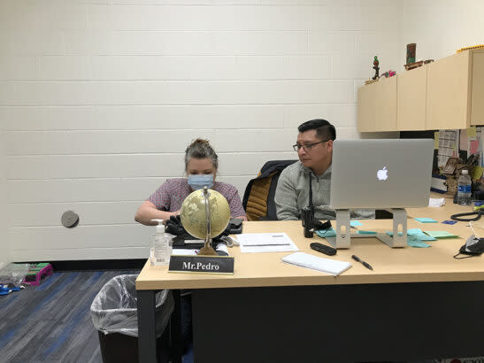 On a health-related call with parents, Mountain View Elementary School parent educator Ted Pedro translates for nurse Tonya Kiser. (Kevin Mahnken/The 74)