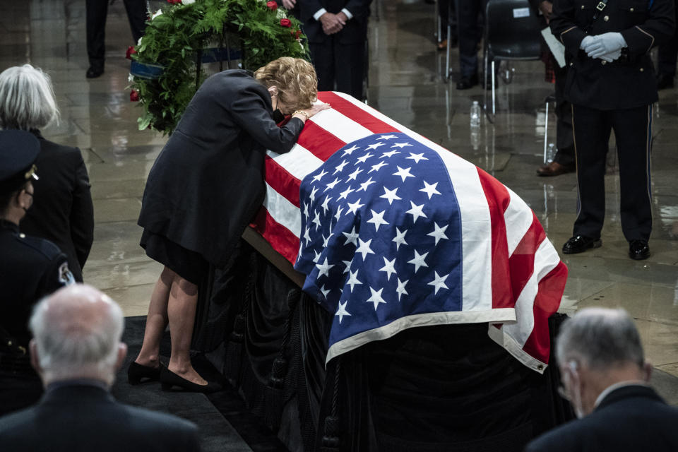 Former Sen. Elizabeth Dole, rests her head on the casket of her husband, former Sen. Bob Dole of Kansas, as he lies in state in the Rotunda of the U.S. Capitol, Thursday, Dec. 9, 2021 in Washington. (Jabin Botsford/The Washington Post via AP, Pool)