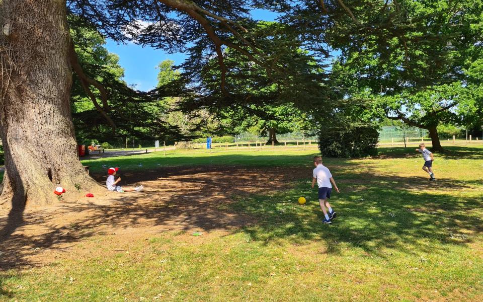 Children socially distance as they play a ball game