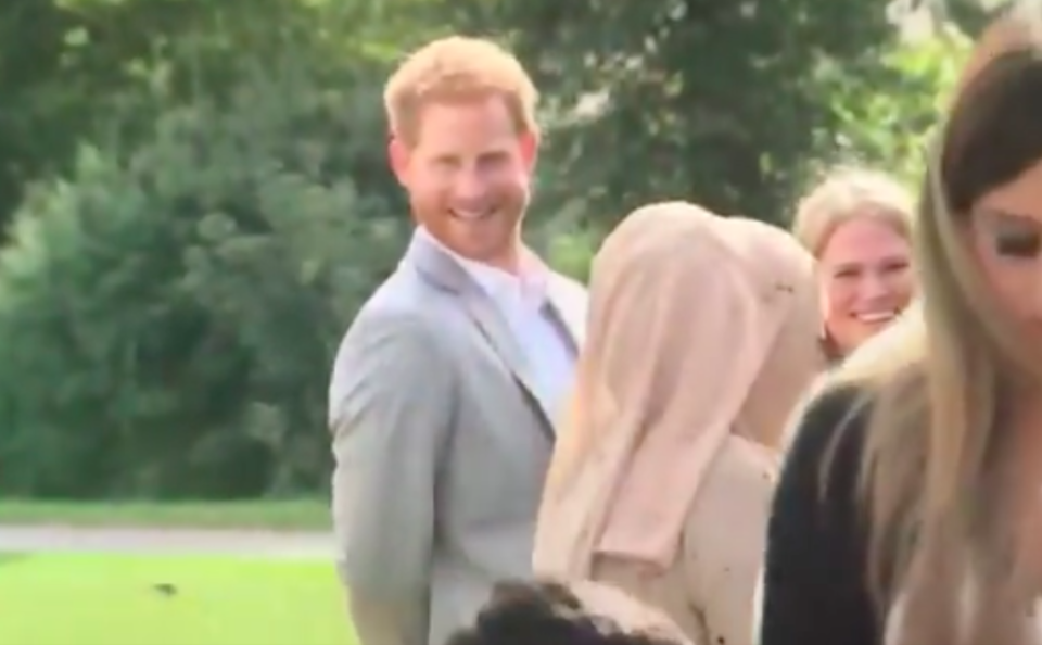 Prince Harry flashed his cheeky grin after he was caught stealing food at Meghan Markle’s cookbook launch. Photo: Twitter/ITV